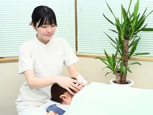 マッサージを行う女性スタッフ