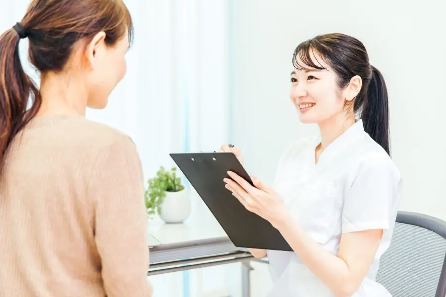 マッサージ前にカウンセリングを行う女性スタッフの写真