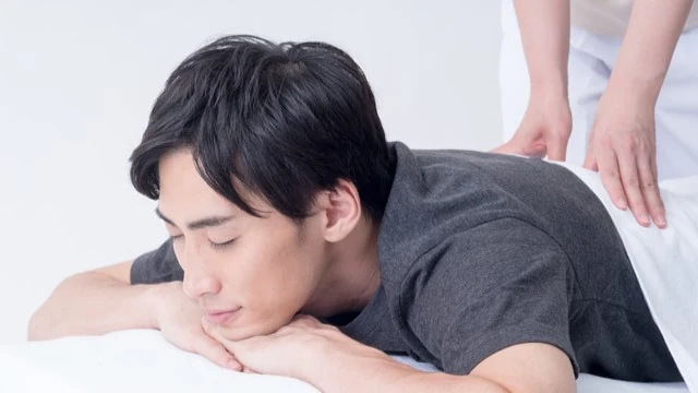 腰痛改善マッサージを受ける男性の写真